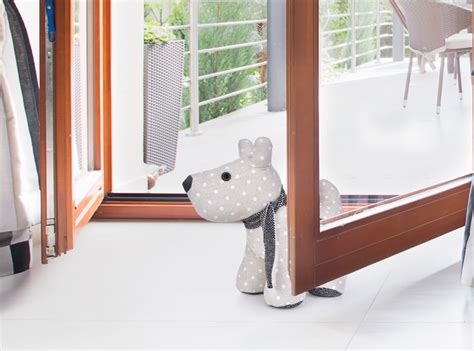 Pes zatláčajúci nosom do dverí s papierikom na kľučke