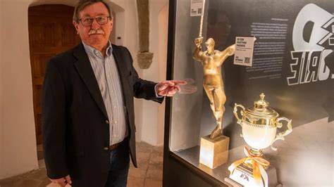 Predseda klubu a trofeje v pozadí